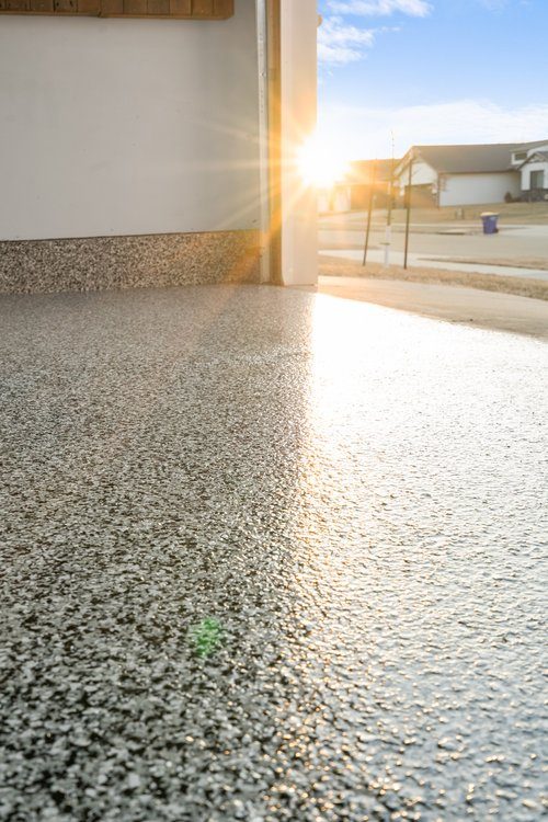 Low-angle view of garage floor at sunset showing flake sheen